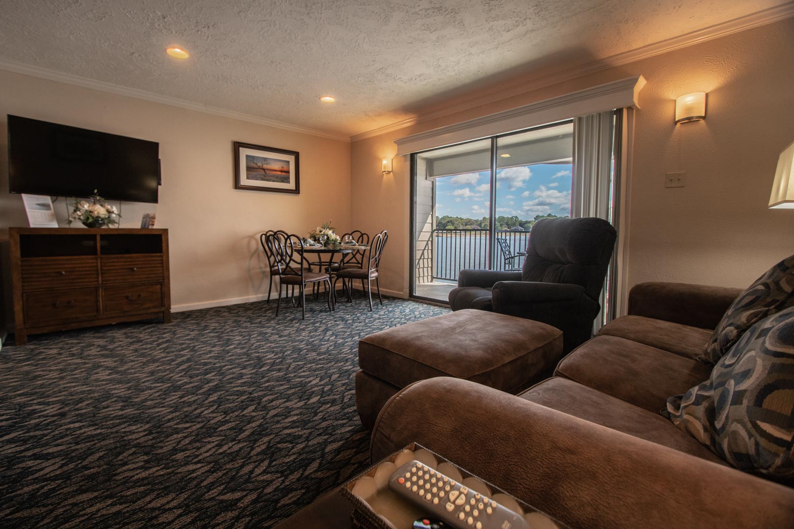 A spacious living room area with access to the balcony at VRI's The Landing at Seven Coves in Willis, Texas.